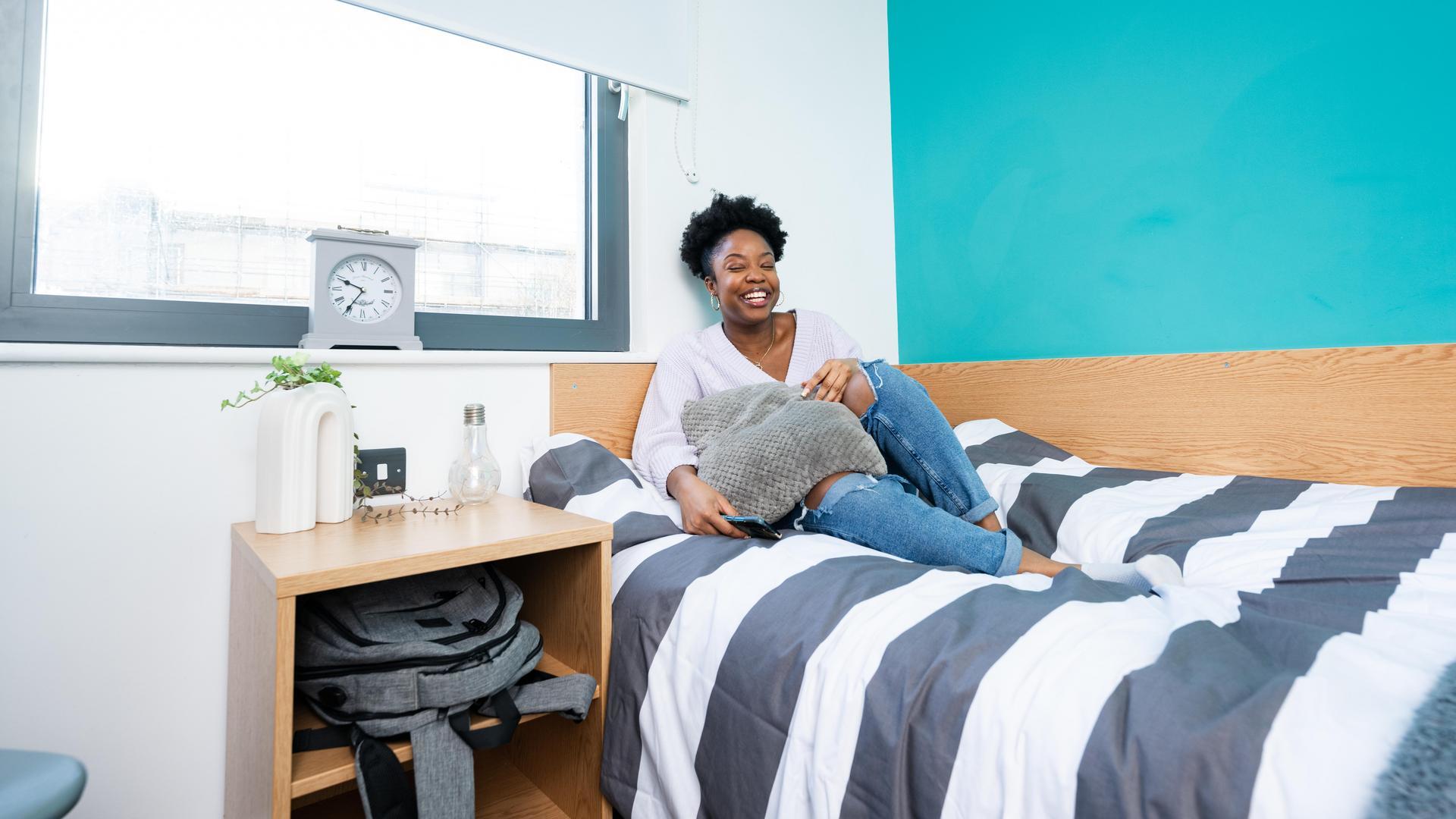 Student on bed in accommodation, Canterbury