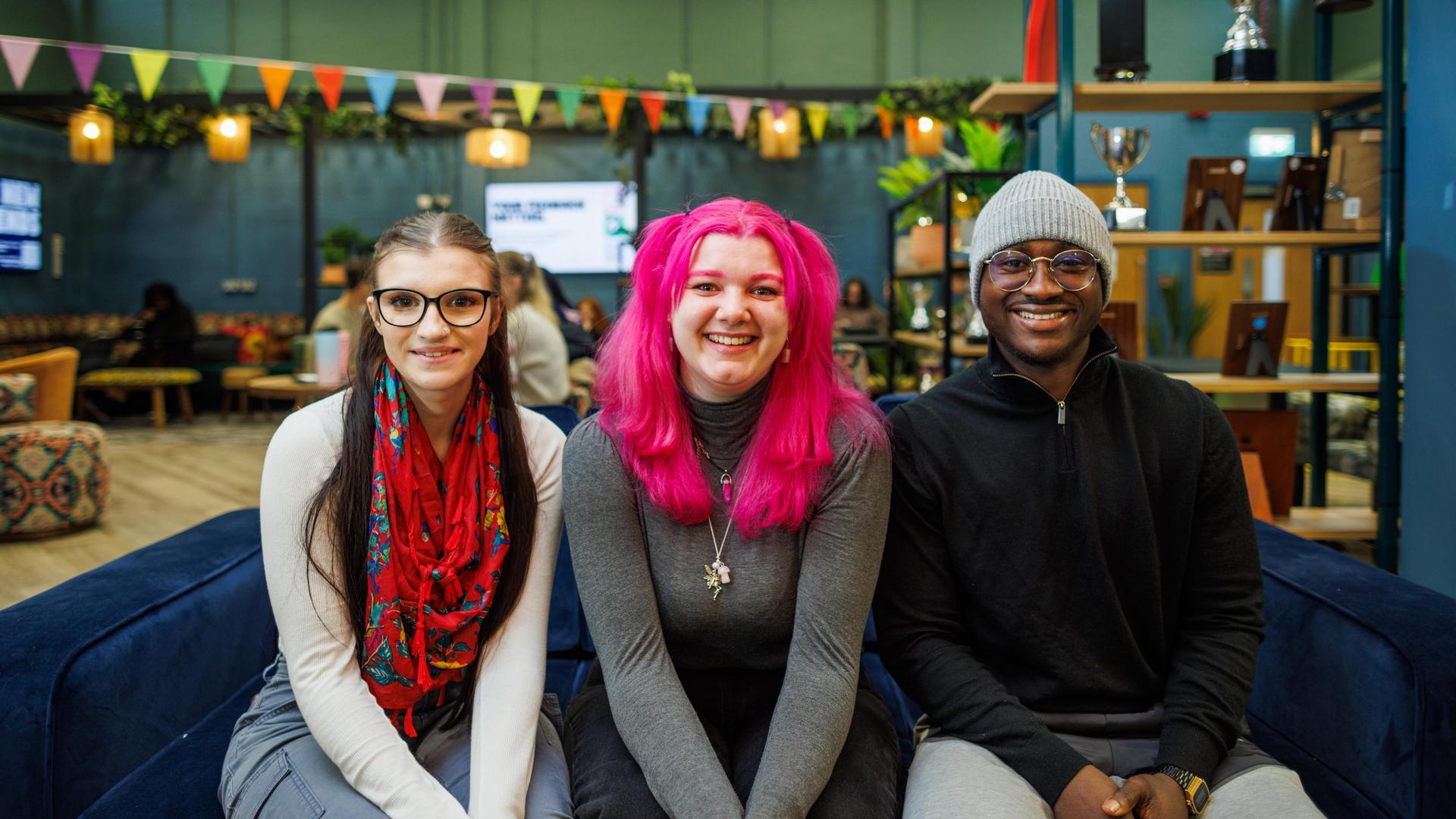 Three students sitting on a sofa in the SU Hub, Canterbury