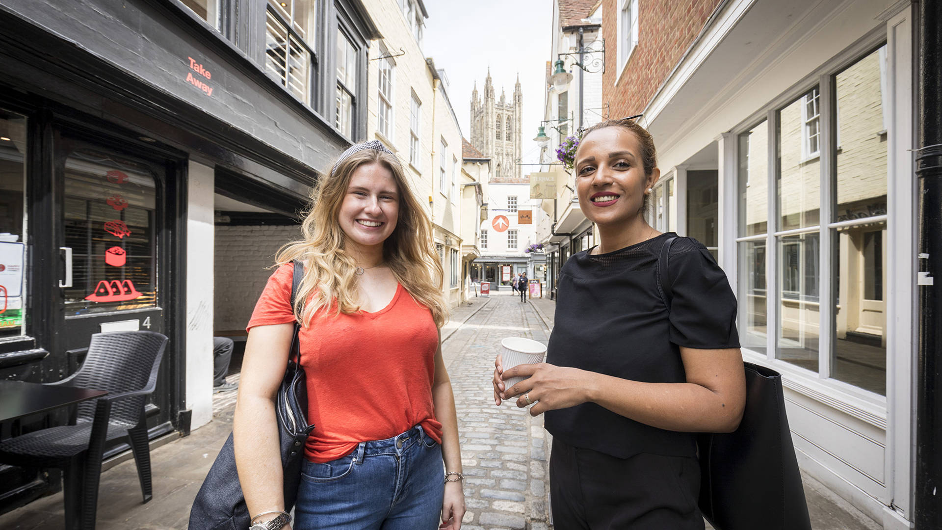 Two students in Canterbury city with the Cathedral in the background